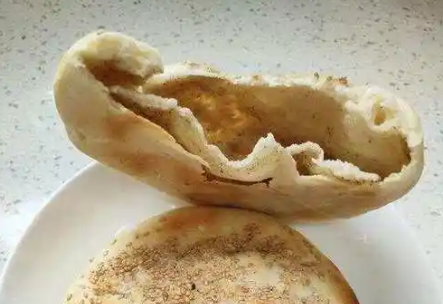 山东聊城吊炉烧饼制作方法，以其外皮酥脆、内里松软、芝麻香浓而闻名